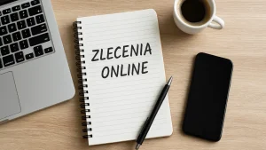 Laptop, notatnik z napisem Zlecenia online, długopis, kawa i telefon – symbol pracy zdalnej i freelancingu przy biurku